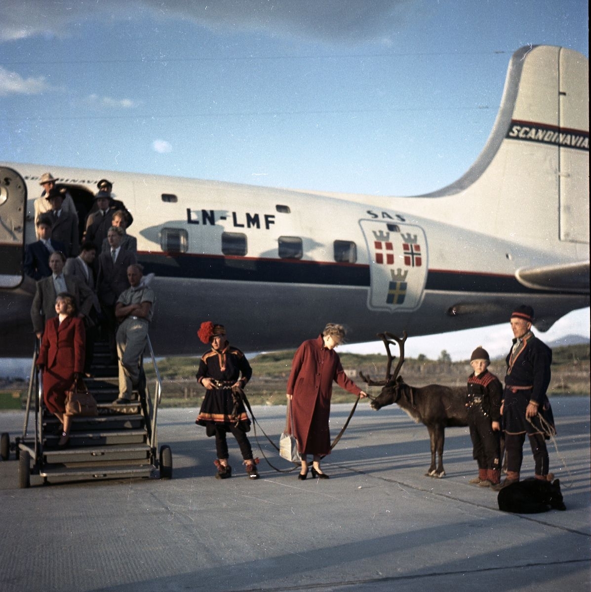 Flypassasjerer ble møtt av familien Karlstad, hunden Dilko, et reinsdyr og turistforeningens guide, da de ankom Bodø flyplass med SAS’ «Midnattssol-ruta». Flyet «Agne Viking» var en DC-6B med registreringsnummer LN-LMF.