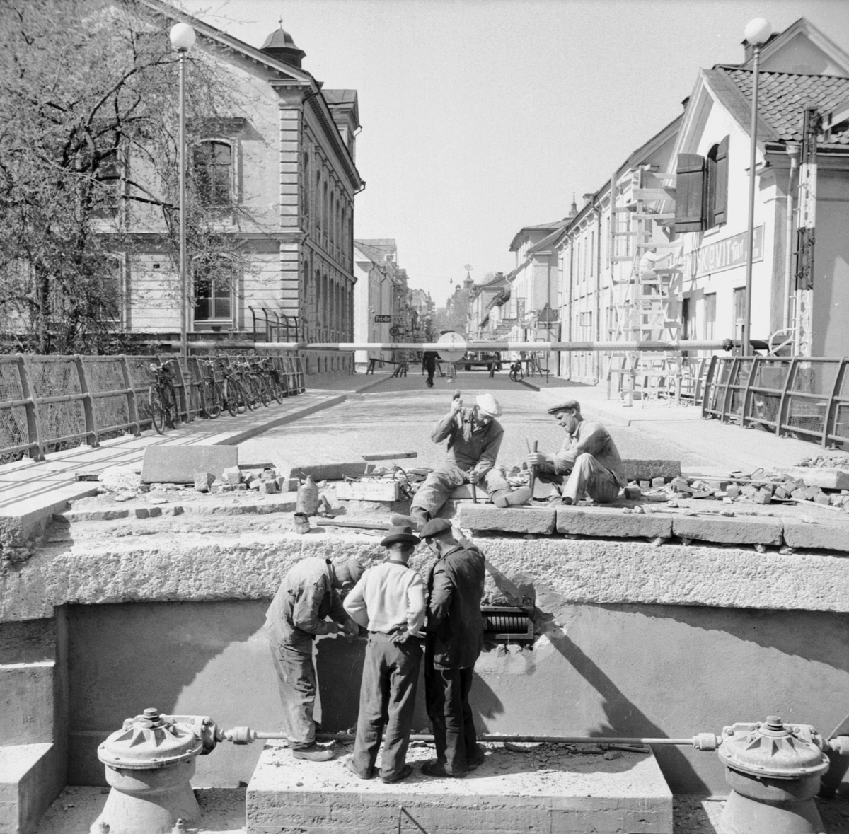 Reparationsarbeten på Stångebro omkring 1950. Bron över Stångån och Kinda kanal var länge porten till Linköpings centrala delar och ännu vid tiden stadens genomfartsled. Till vänster bortom brofästet reser sig det gamla fattighuset för kvinnor och till höger stryks gaveln till Stångebro Nya Tvättinrättning.