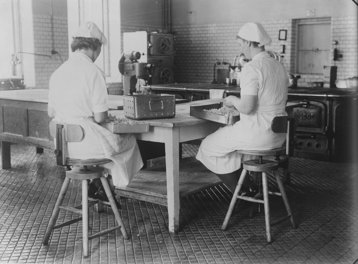 Fotografi från Arbetarskyddsstyrelsens arbetsplatsdokumentationer. Kvinnor på okänd arbetsplats. Bilden visades vid årsredogörelsen 1939.