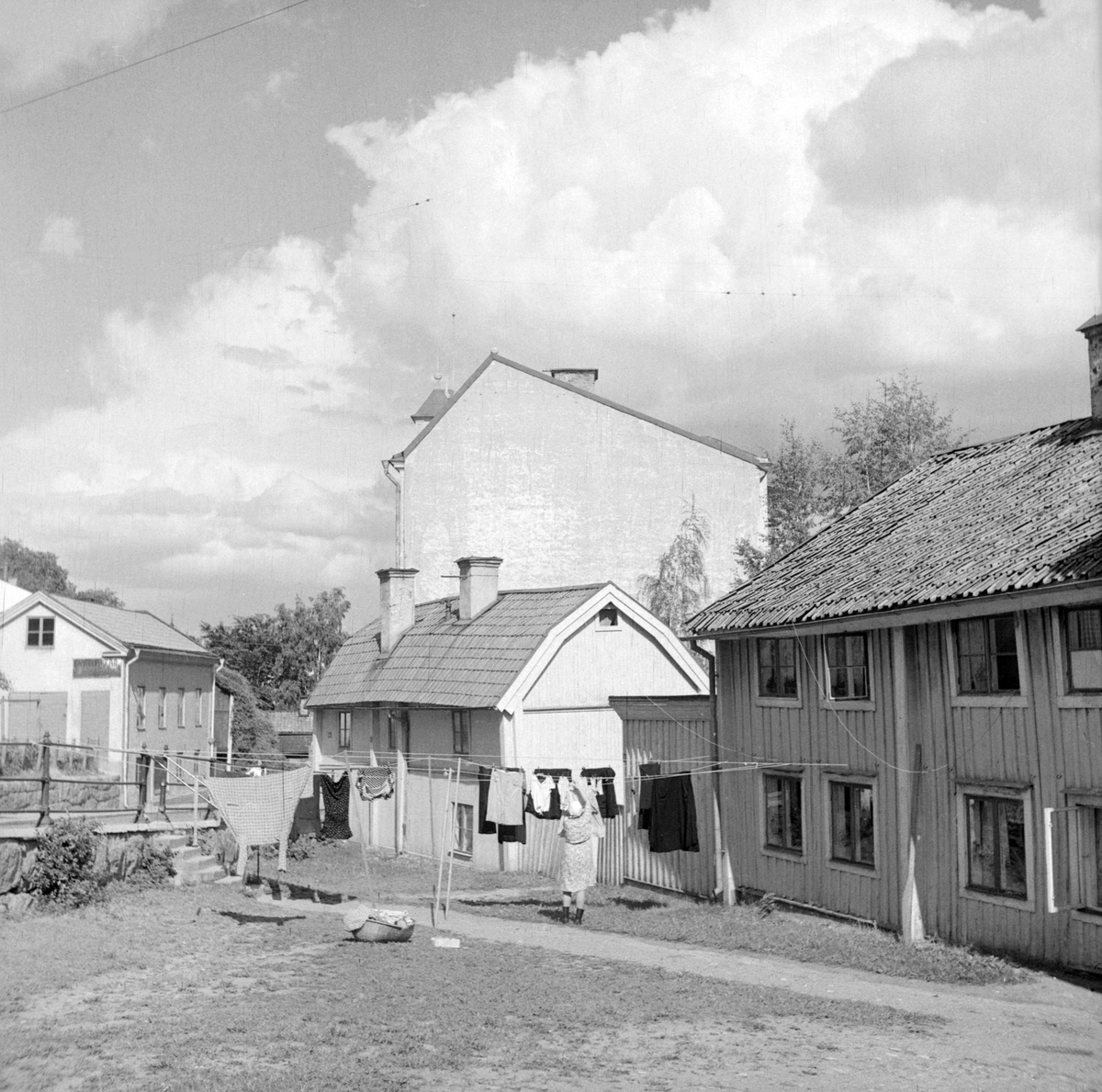 Miljön vid Nygatans övre del. Husen till höger bar vid tiden adresserna Nygatan 62 följd av nummer 58. Deras vinkelställda lägen mot gatan förklaras av att de i äldre tid låg utmed Sankt Korsgatans västra del, som lades igen när Nygatan förlängdes under 1870-talet. Närmast den så kallade Anderska gården. Uppkallad efter konstnären Knut Ander (1873-1908), som växte upp i huset. Bostadshuset och tillhörande stall monterades ned 1954, för att året därpå återuppföras i Gamla Linköping. I huset med det brutna takfallet bodde länge systrarna Elin, Nanna och Sigrid Pettersson. Även detta hus kom vidare att flyttas till Gamla Linköping, där det stod återuppfört 1963 som Systrarna Petterssons gård.