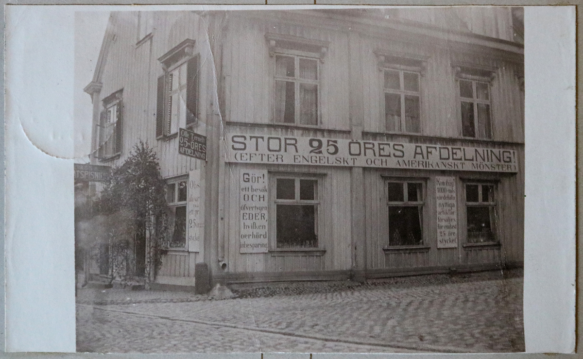 Vykortet har motiv av Olle Ternells affär i hörnet av Kungsgatan/ Rådhusgatan, en butik han öppnade omkring 1910.

Vykortet är  inklistrat i vykortsalbum nr. EM06774_d.