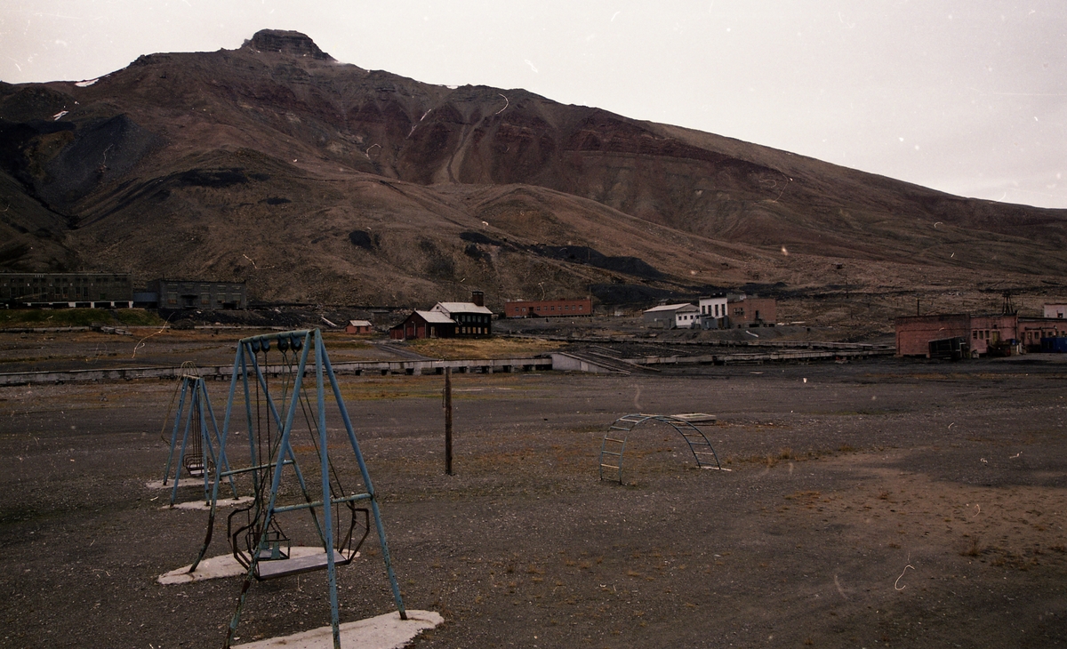 Fra reportasje i Svalbardposten nr. 32 18. .august 2000. Reportasjen om opprydning og hotell/turisme i Pyramiden. Lekeplassen i Pyramiden, med brannsatsjonen i bakgrunnen.
