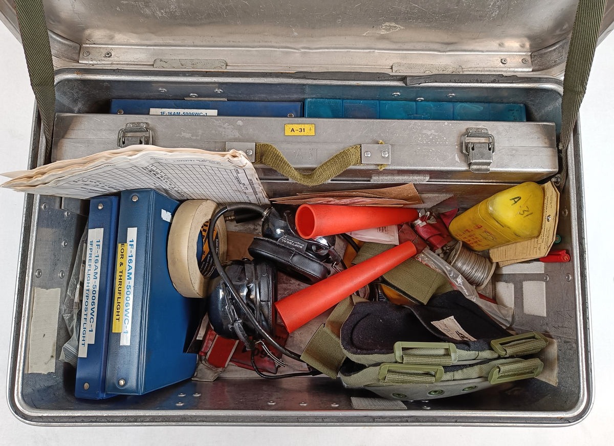 Personlig verktøykasse for F-16 teknikere som jobbet på line. Inneholder håndbøker, diverse skjema, forskjellige verktøy og personlig utstyr som kunne bli brukt på line. Innhold i kassen er delvis vist på bilde.
