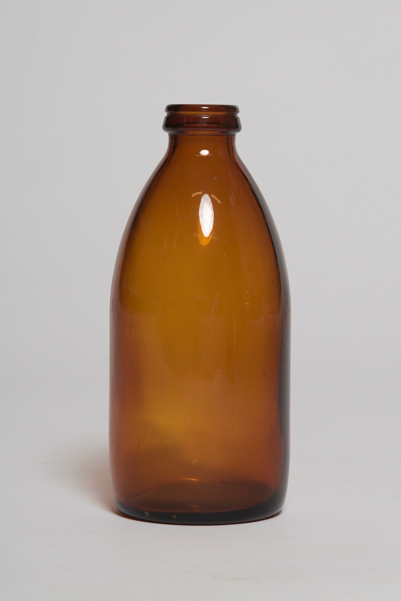 èn brun glassflaske for bruk i hjemmet. Melkeflaske? Produsert ved Moss Glassverk, ca 1966.