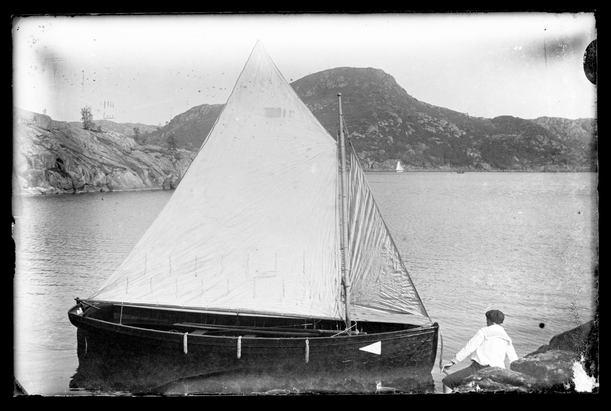 En gutt og en seilbåt i Svanavågen på Eigerøy