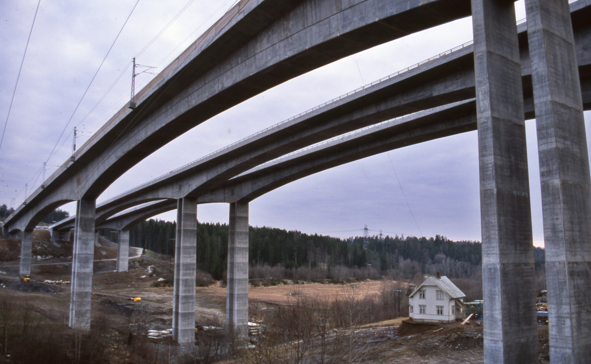 Hølendalen. Nye betongbruer for dobbelt-sporet jernbane (lengst øst/nærmest) og motorvei E6 under oppføring.  Veien ikke ferdig ennå. Jernbanebru l=416 m, h=50 m, spenn l=128m