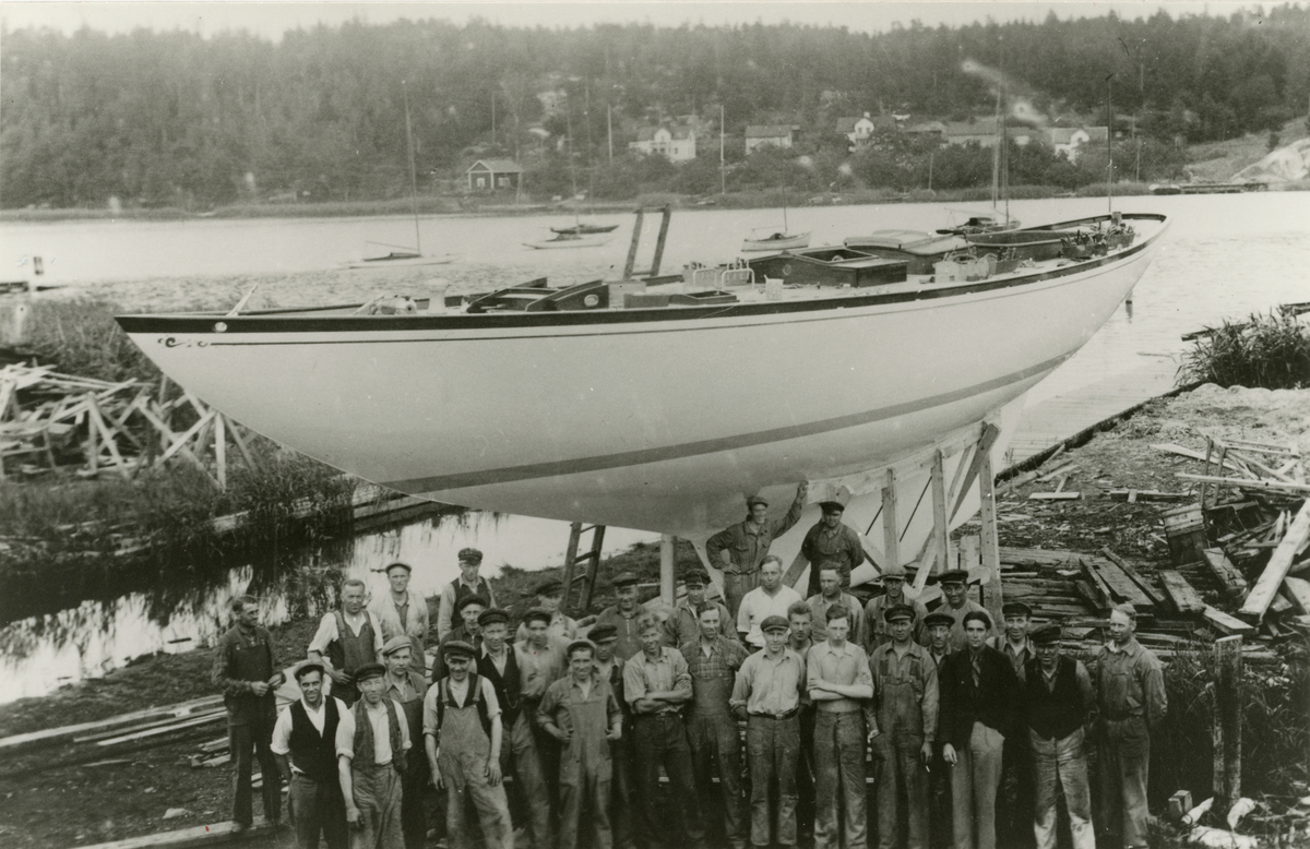 Sjösättning av havskryssaren Glädja vid Holms varv i Gamleby, omkring 1938. Varvsarbetarna samlade framför båten. Byggd för export till USA.