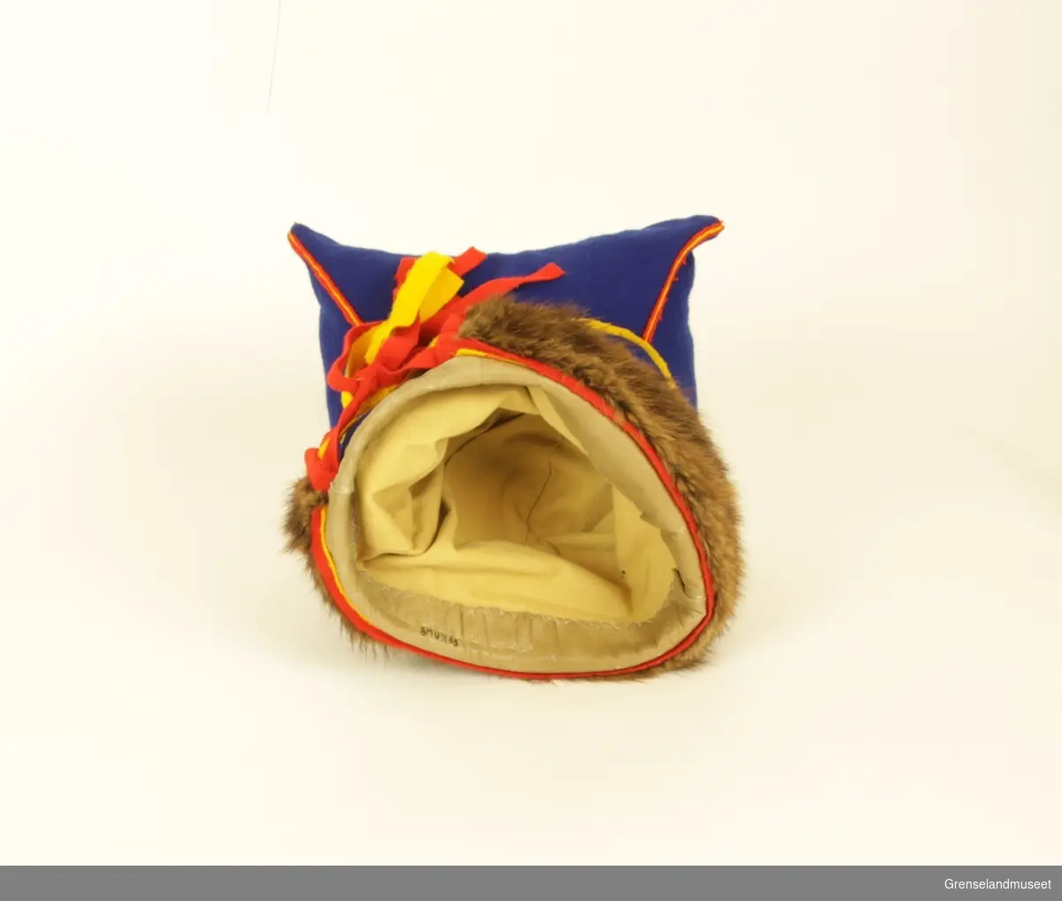 Gjenstanden er samisk firkantlue (herrer) av blått ull og med brun pelskant. På luens innside er kanten som går rundt hodet lagd av skinn. Luens sømmer er av rød og gul ull, og bandene bak i nakken er rød øverst, gul i midten, og rød nederst. Luens firkantete fasong kommer av at hver ende av firkanten er stappet med stoff.       