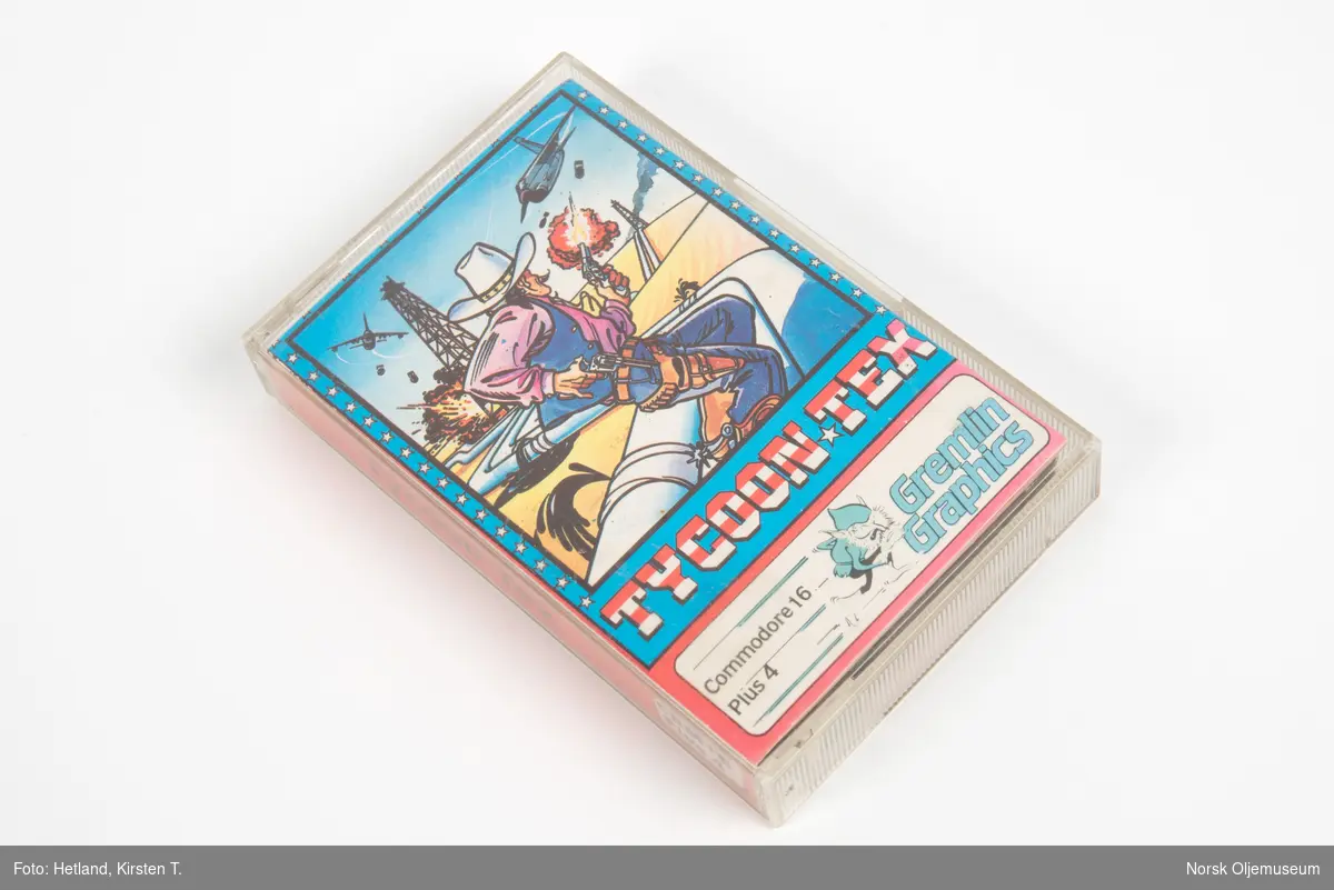 Spillkassett til Commodore 16 med spillet Tycoon Tex. Spillet handler om en cowboy som patruljerer en oljeledning. Instruksjoner for spillet finnes på innsiden av omslaget i etuiet.