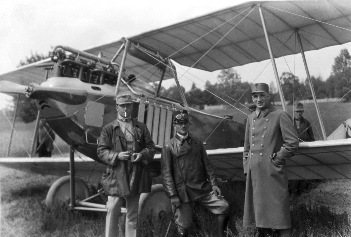 Tre militärer från Österrike-Ungern står framför flygplan Albatros på ett flygfält under första världskriget. Edmund Sparmann till vänster.