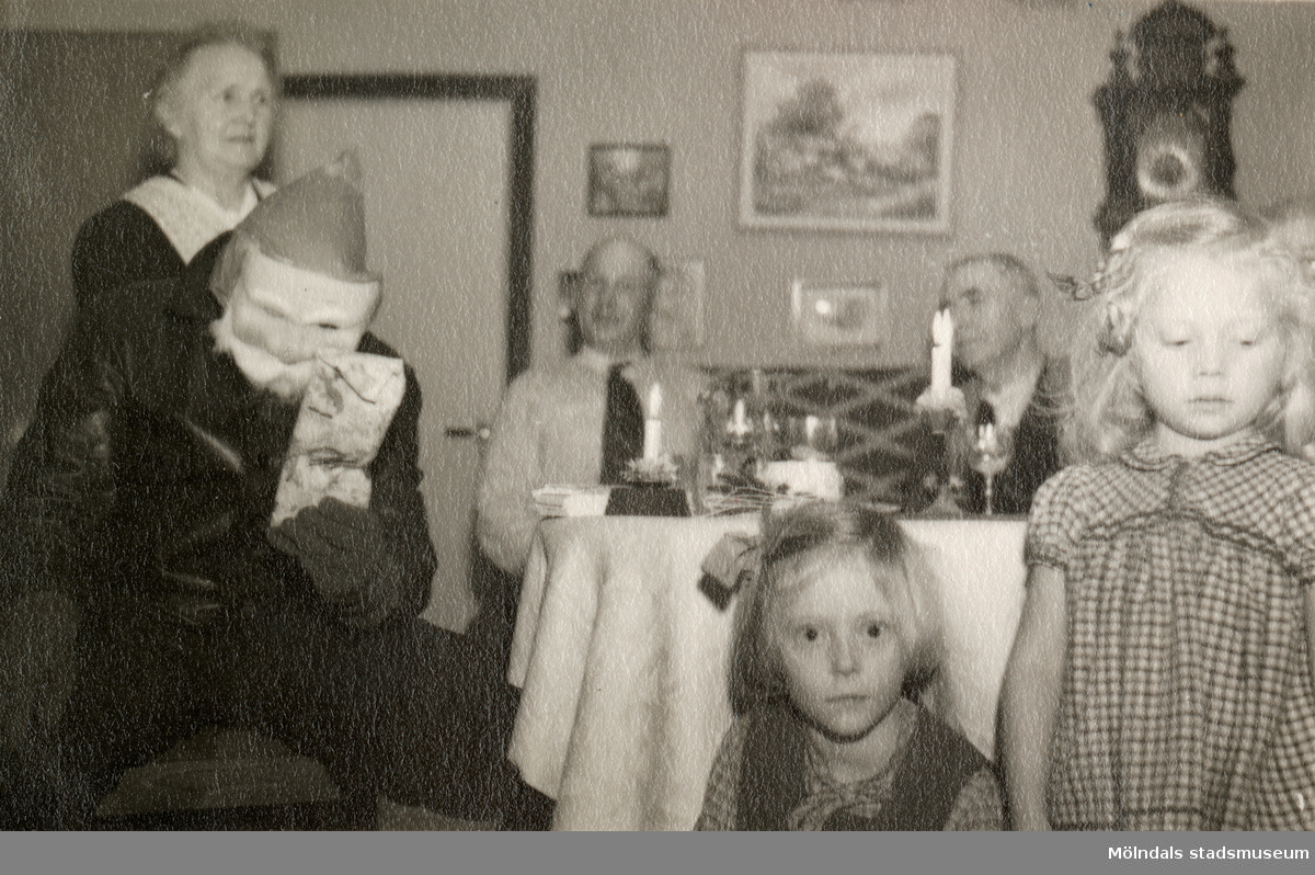 Julafton på övervåningen hemma hos familjen Pettersson, Gamlehagsvägen 17 i Torrekulla år 1950. Från vänster ses Nora Krantz (1879 - 1955), Jultomten?, Karl Holmberg och Carl Krantz (1880 - 1956). I förgrunden ses systrarna Karin Pettersson (född 1947, gift Hansson) och Eva (född 1944, gift Kempe), barnbarn till Nora och Carl.