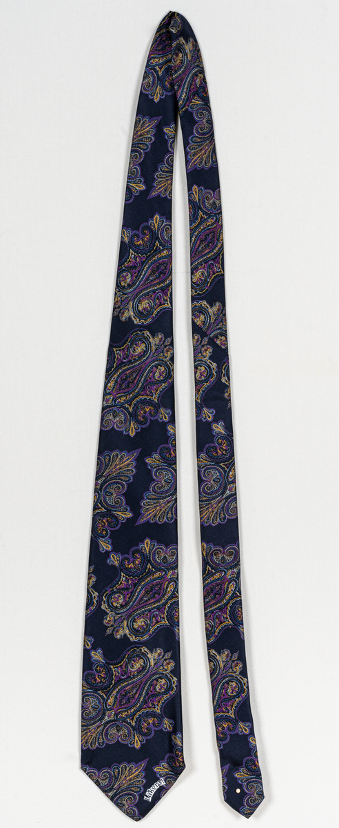 Mörkblå slips med flerfärgat mönster.