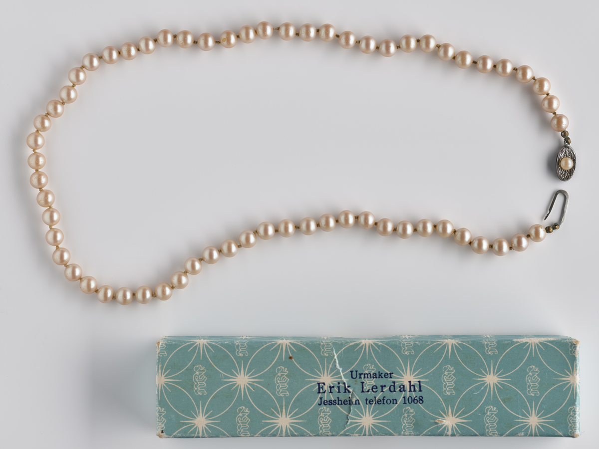 Perlekjede med pappeske i lys turkis farge. 

Diverse smykker som har tilhørt Synnøve Brændshøi. De fleste er nok fra 40- og 50-tallet.