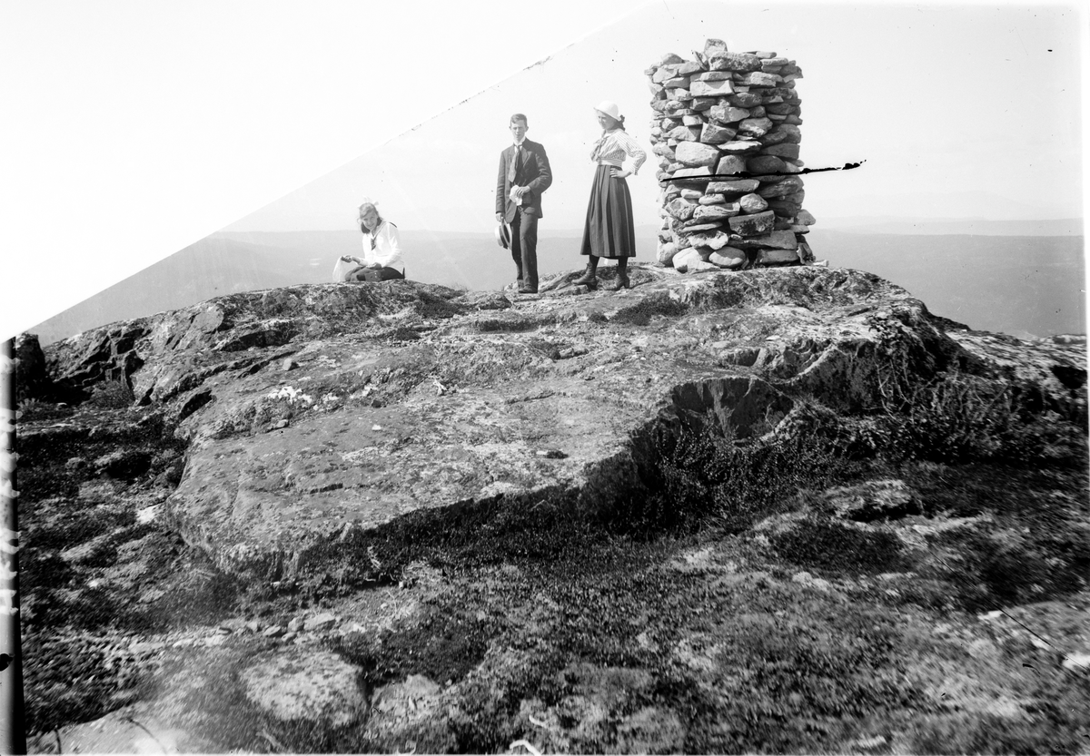 Fjellandskap
1 mann og 2 damer ved en varde på fjellet.
Lite tekst
