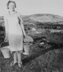 Alma Ellinor Mikalsen bærer vannbøtter i Børøsundet, Hitra.