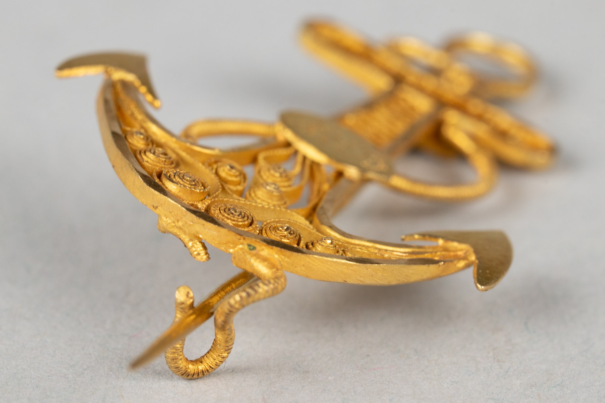 Nål i gullfiligrans, formet som et anker. Dekorert med monogram