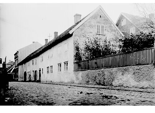 Gamla gästgivaregården på Storgatan 42 i Falkenberg, kallas Falkmanska huset och är ett av stadens äldsta byggnader. Byggnaden uppfördes av borgmästare Sören Sörenson på 1690-talet med krogstuga på bottenvåningen och resanderum på övervåningen. Hans son Hans Falkman har gett huset dess namn.
Bilden är tagen mot norr, troligen på 1910-talet. Fotograf okänd.