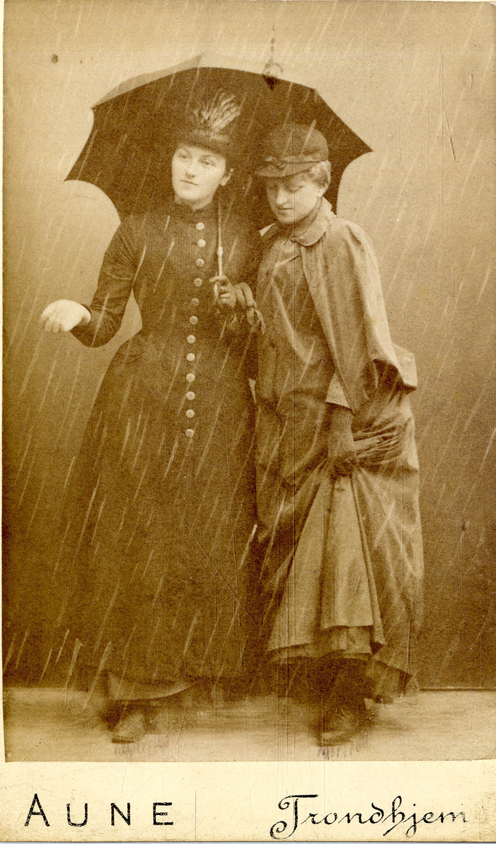 Studioportrett av to kvinner under en paraply