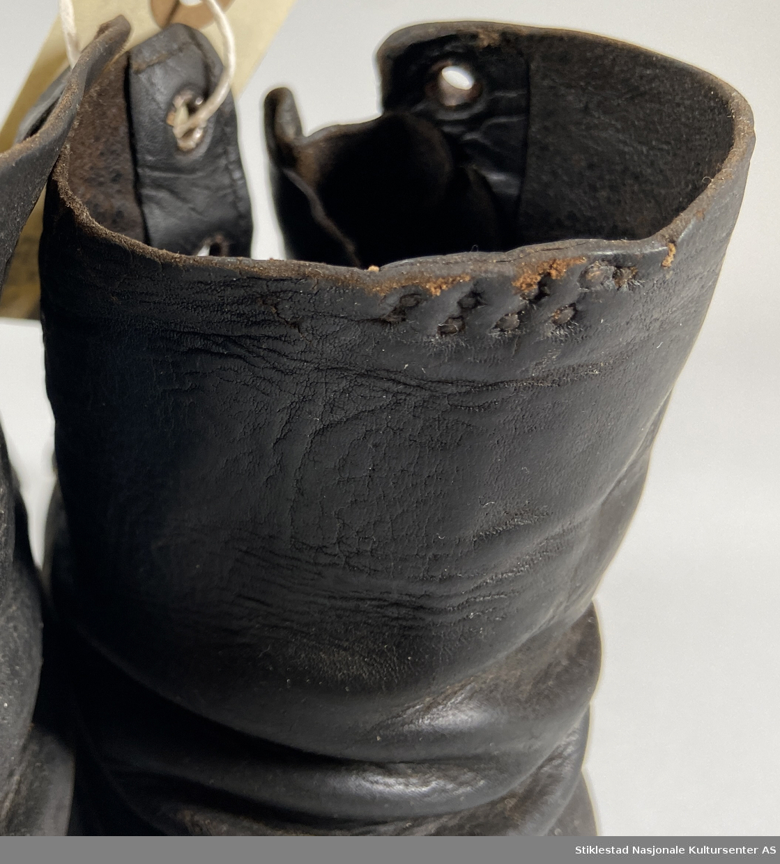 Et par lauparsko/skinnsko uten snøring. Skaftet har maljer i metall. Påsatt ekstra lærsåle foran på skoene. Underlær er sydd sammen med overlæret. Uforet sko.