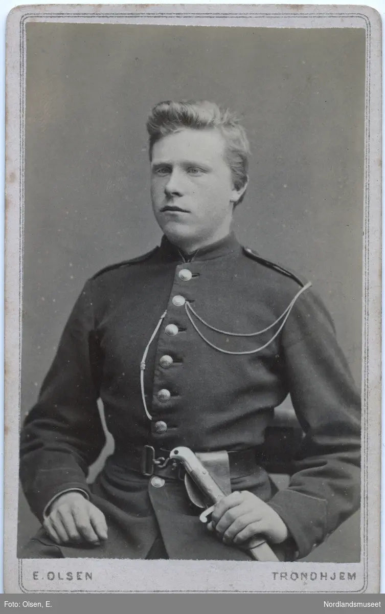Portrett av en ung mann i uniform. Sittende halvfigur. Ludvig Johansen Fremmerlid, senere kjøpmann på Bogøy i Steigen.