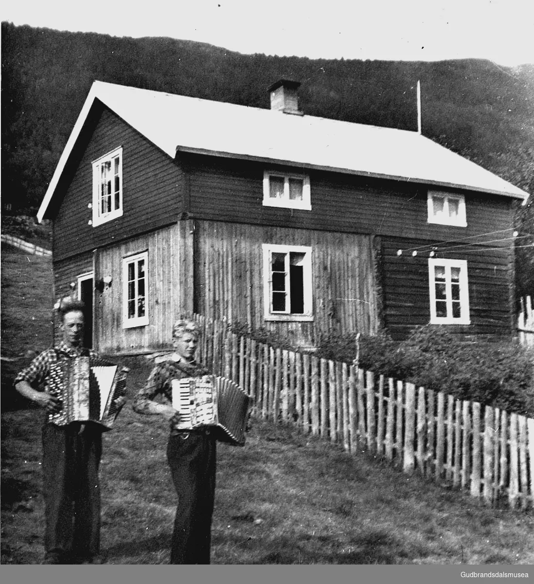 Johannes Løkken (f. 1915) og Jon Horten med trekkspel ved stugu i Husom