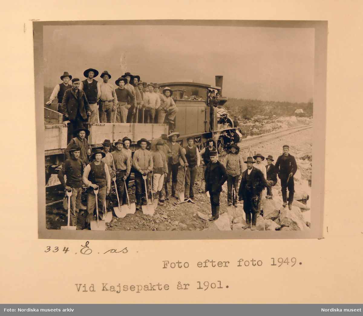 Grupporträtt av rallare stående på och intill tåg vid järnvägen, Kajsepakte år 1901.