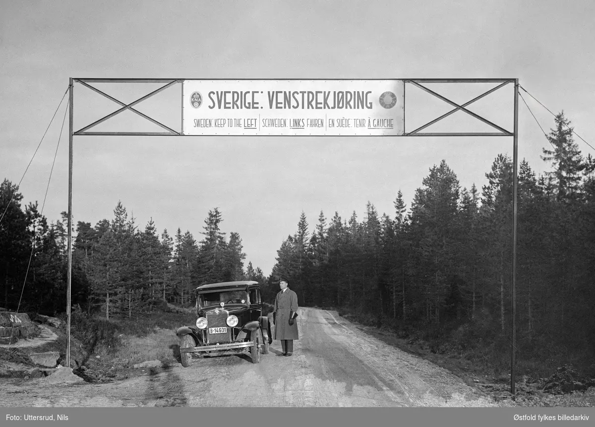 Antakelig grenseovergangen ved Hån, Ørje. Skilt for venstrekjøring i Sverige. Lensmann Sverre Lislegård, Øymark,  står ved bilen hans, en Chevrolet, 1930 modell. 
Bilkjennetegn, B-14601 (Info fra Bilboken 1930)

Sverre var langrennsløper pg skihopper (og trener), og deltok blant annet i skihopp i vinterolympiaden i Sveits i 1928, i krigsårene 1940-45 var han kurer.