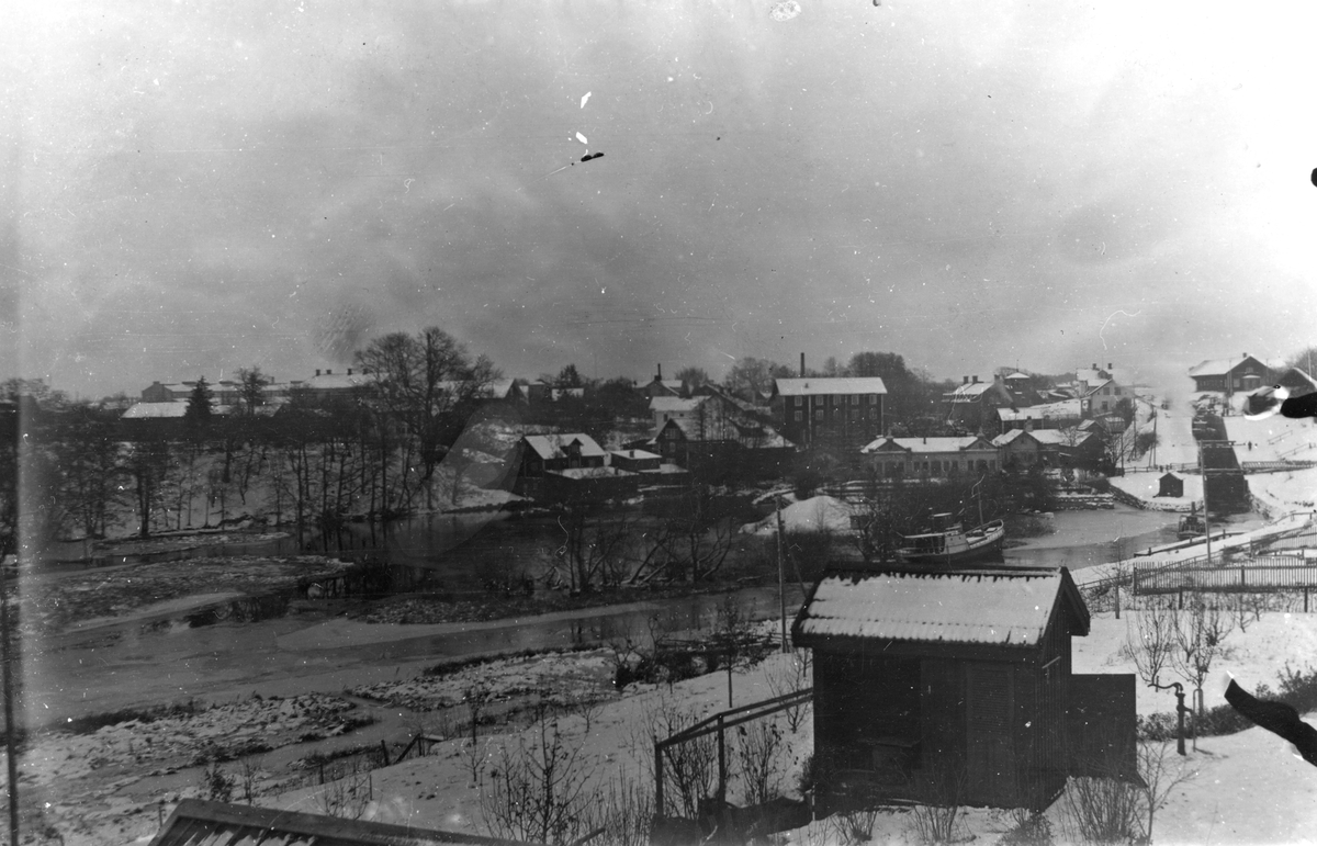 Ett medfaret fotografi som främst publiceras för hängivna lokalhistoriker. En vy över Tannefors kvarnby där vissa sällan avbildade miljöer åskådliggörs, exempelvis Snuggans kvarn som ses något till vänster om bildens centrum. Bilden har daterats till 1921.
