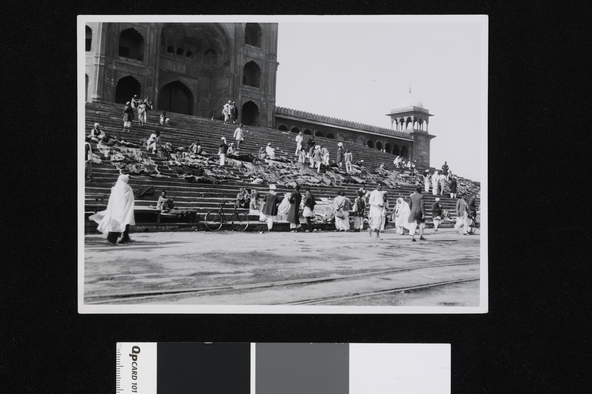 Mennesker i en trapp der det kan se ut som det forgår salg av ulike varer. Fotografi tatt i forbindelse med Elisabeth Meyers reise til India 1932-33.