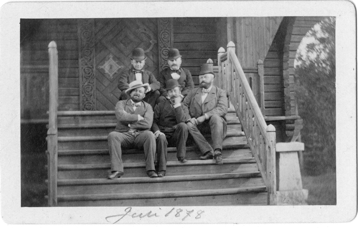 Foto av menn på trapp, tatt i 1878. Første rad til venstre er muligens kommandør Thorvald Dannevig