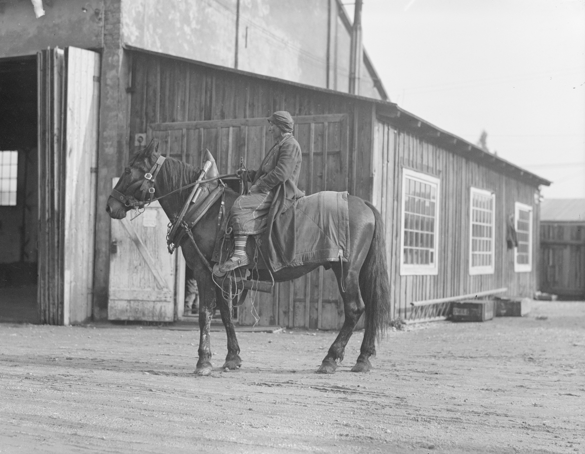 En kvinna med kjol och sora kläder sitter till häst i Österrike-Ungern, 1910-tal. Hästen är utrustad med seldon.