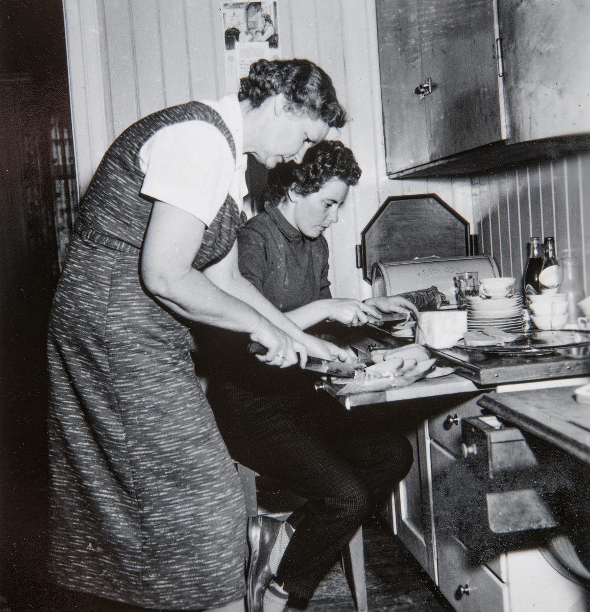 Gudrun Sørum og datteren Gerd Sørum lager til brødmat hjemme på kjøkkenet til Gudrund. I Kirkevegen i Brumunddal. Gerd ble senere gift med Odd Aspeli.