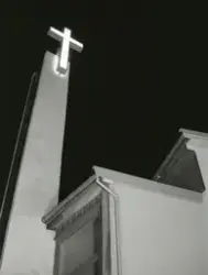 Lyssatt kors ved klokketårnet til den katolske kirka St. Mik