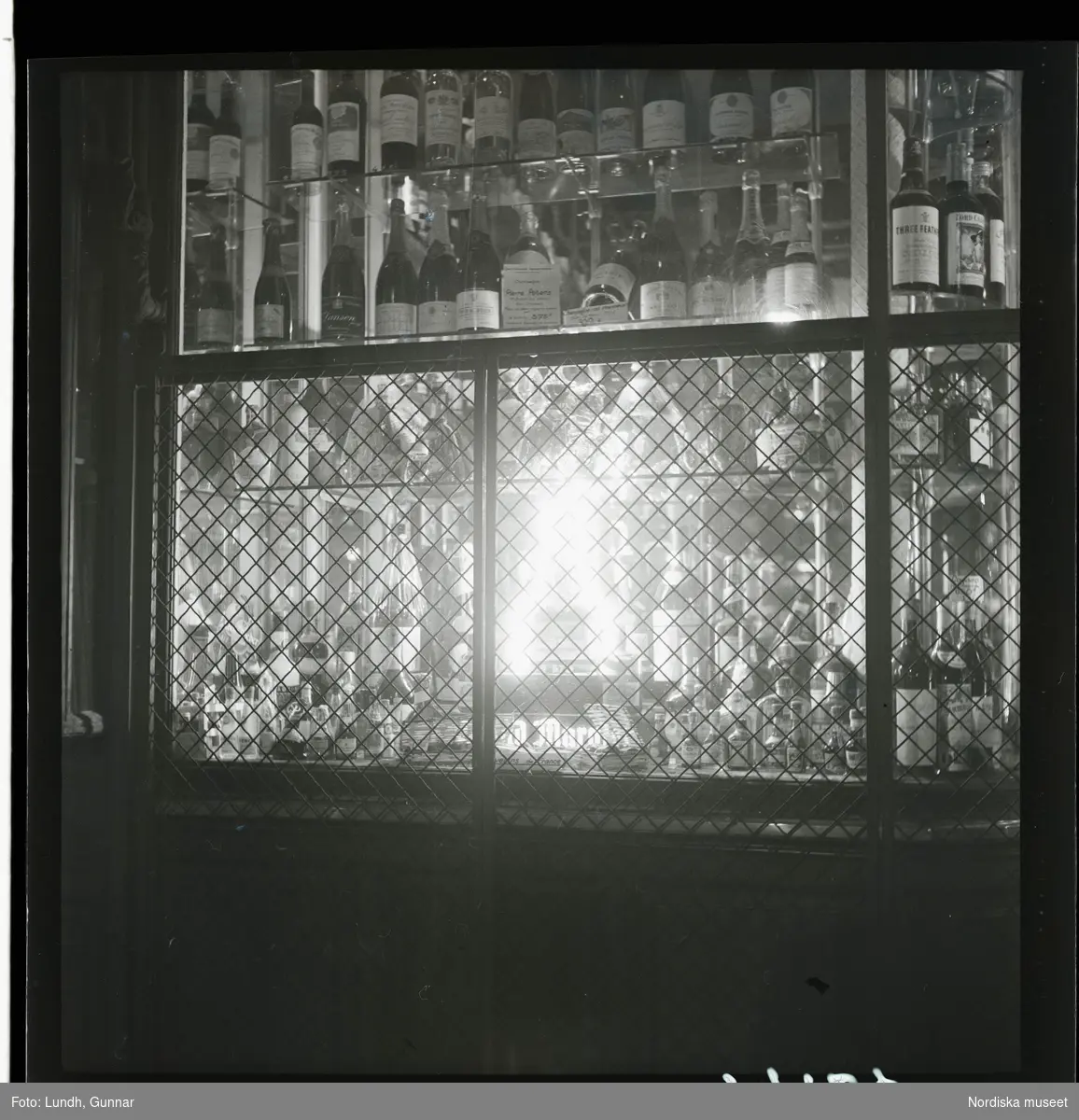 1950. Paris. Spritflaskor i fönster