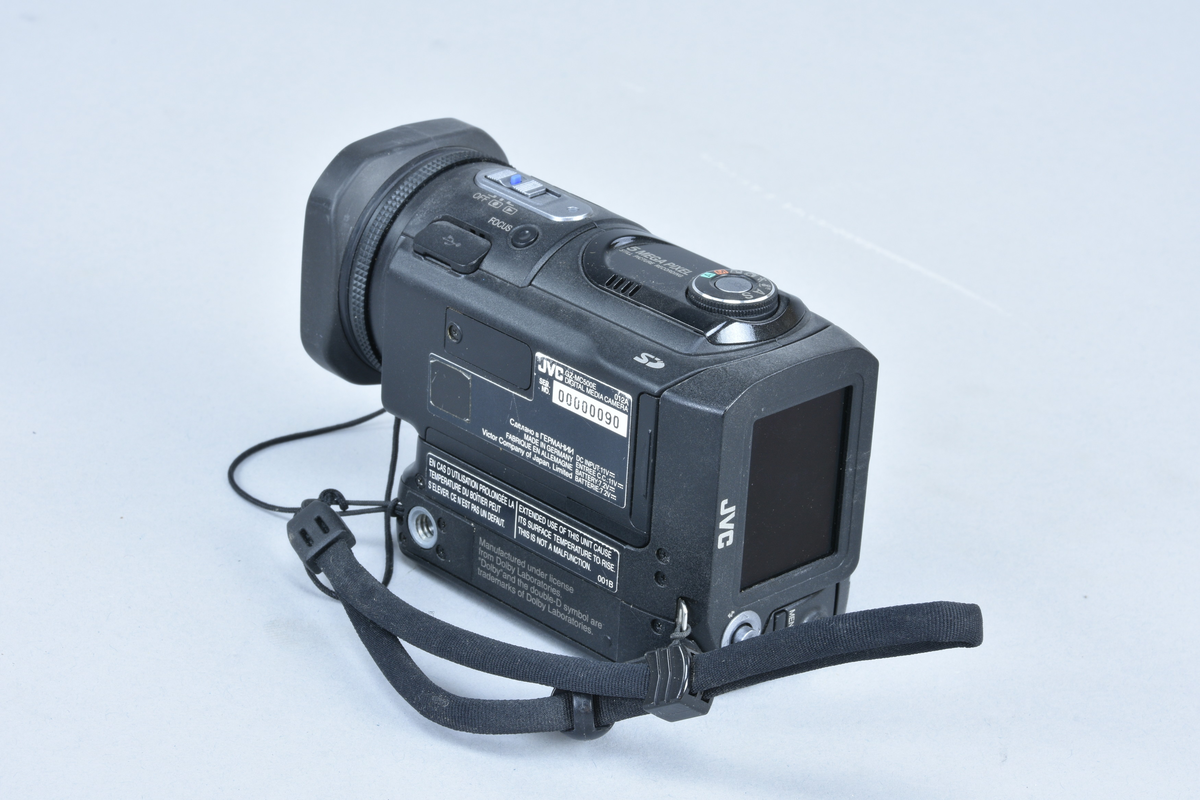 Digital mediakamera 3 CCD, 5 megapixlar med inbyggd stereomikrofon JVC typ GZ-MC500E nr 00000090 (förserieexemplar). För lagring på minneskort typ Microdrive. Zoom 1:1.8 brännvidd 3,2-32 mm med autofokus, 10x "optical zoom". Vridbar så att displayen på baksidan är lätt att se. Medföljer 4 GB Hitachi Microdrive med Compact Flash II -anslutning samt batteri.