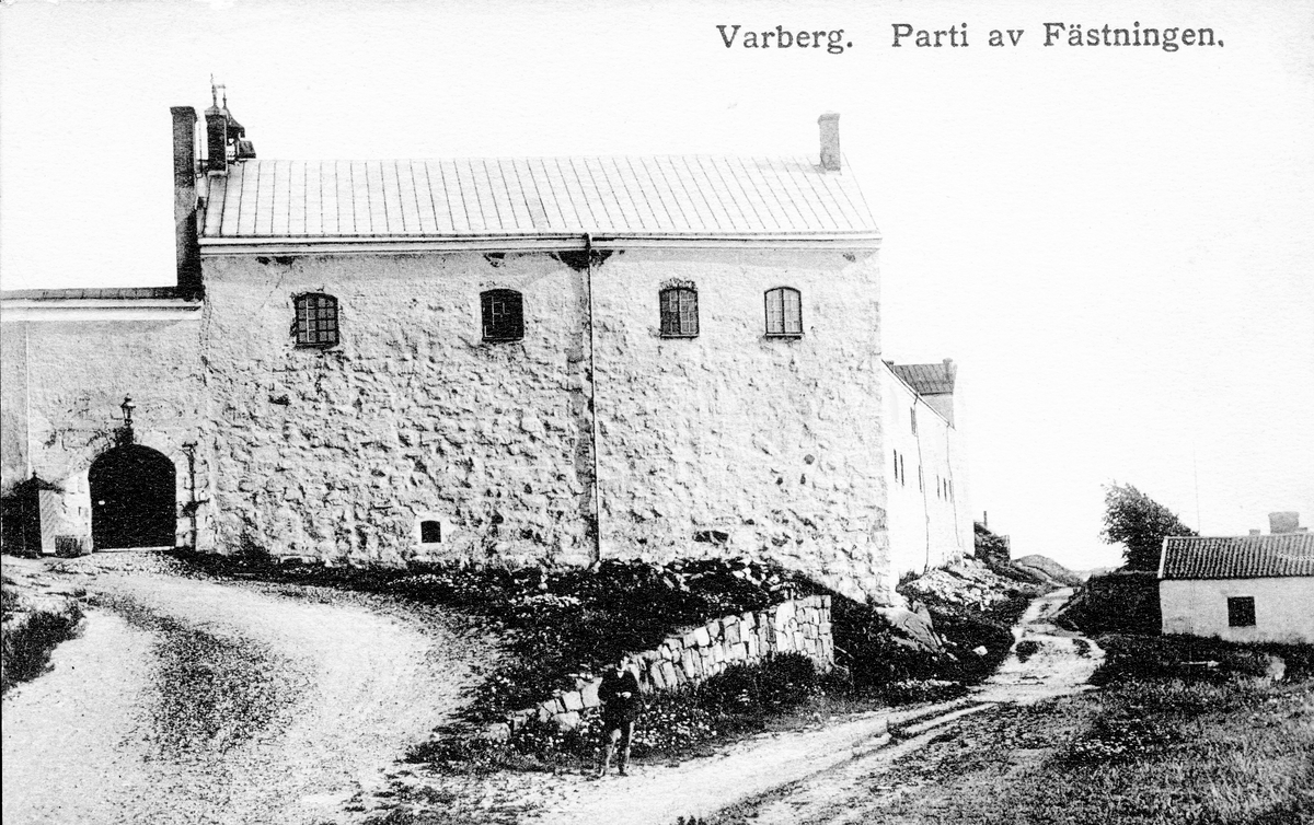 Vykort, "Varberg. Parti av Fästningen." Norra slottslängan, sedd från norr, som ingick i danske greve Jakob Nielsens stenborg, färdigställd omkring år 1300. Det lilla huset till vänster fungerade som tvättstuga på fästningen.