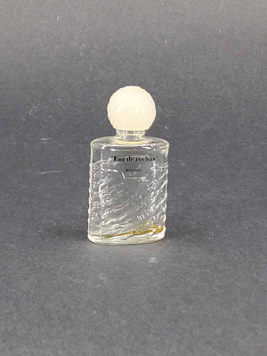 Parfymflaska, glas med plastkork. med rester av parfym: Eau de rochas