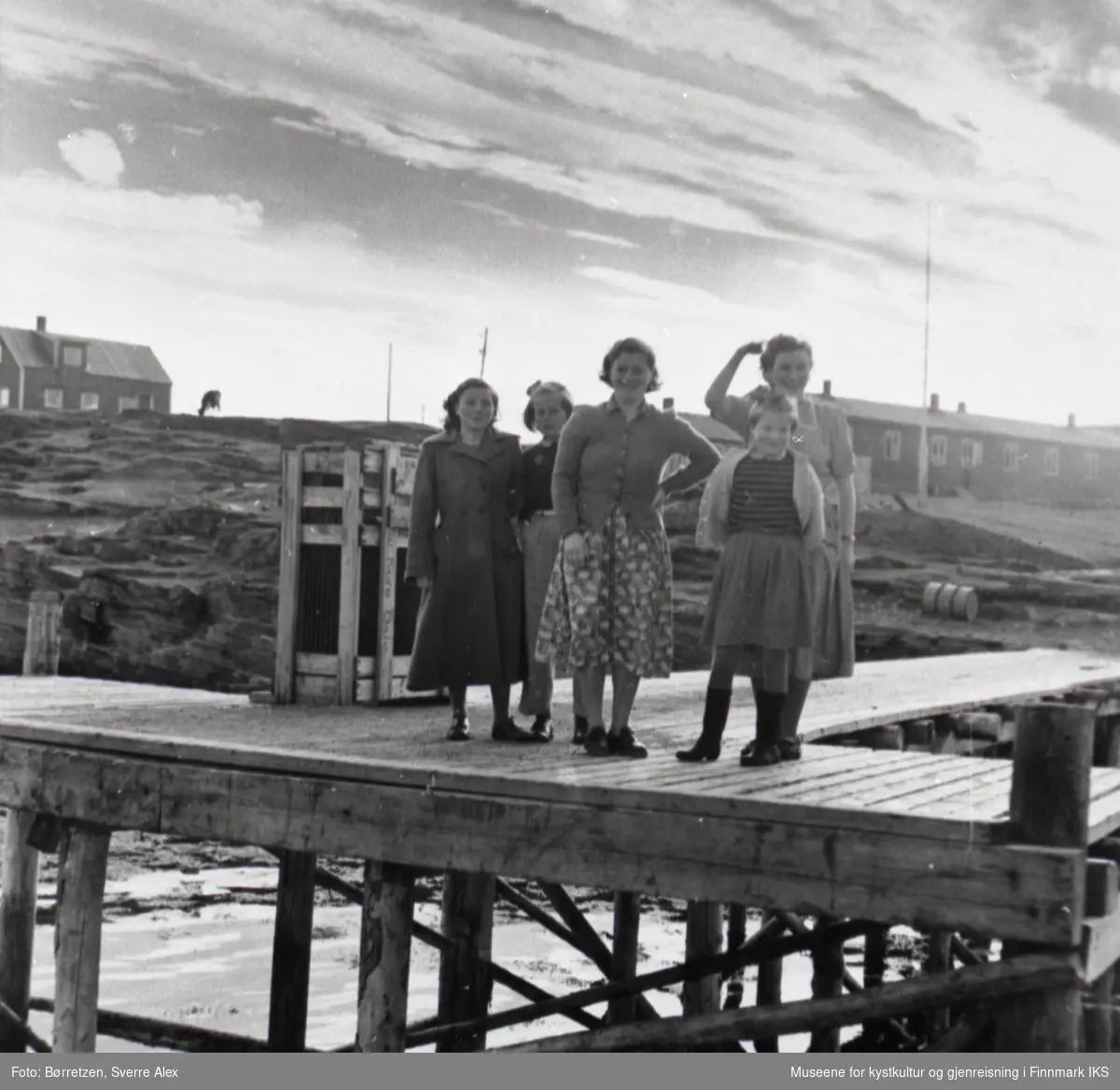 Skoleinternatet i Repvåg. Elever og betjening på kaia. I midten husmor Judith Andreassen. Til høyre ser man skolebrakka. Høsten 1952.