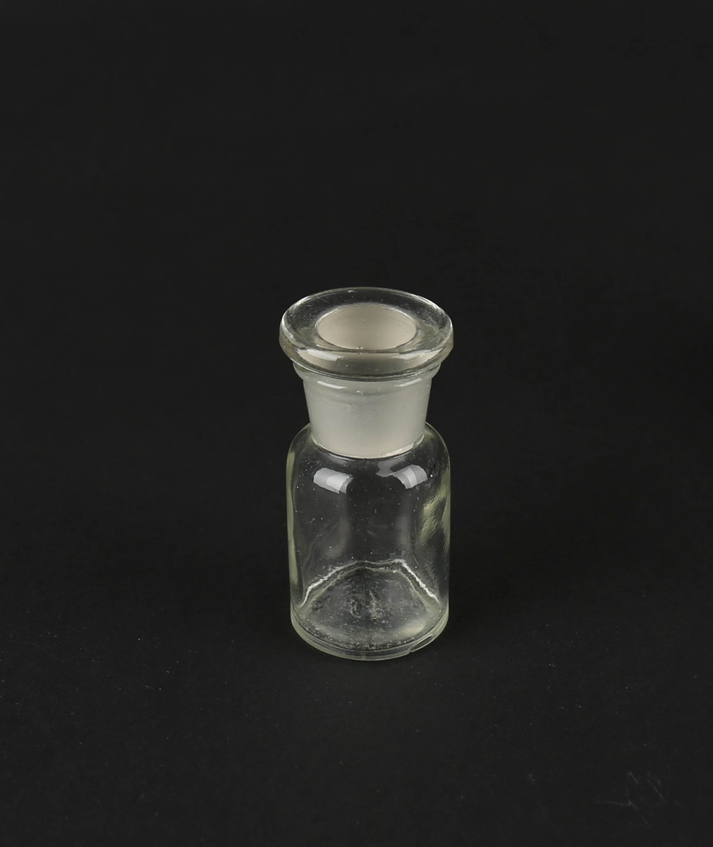 Blankt apotekglass med slepen glasskork som sitter fast. Volum 15mm.