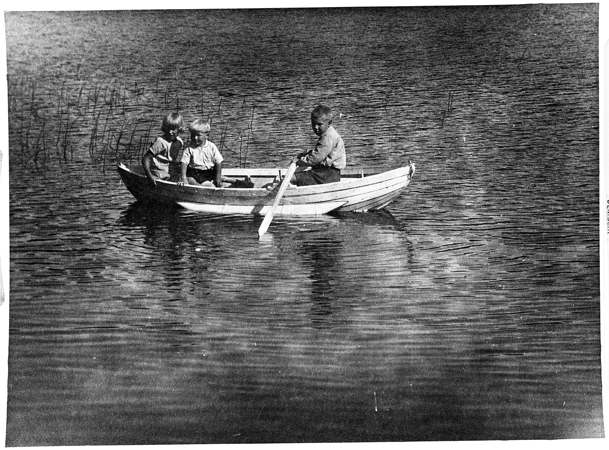 Tre barn i jolle på Hommelsjøen på Totenåsen 1930. Personene er: Inger Nilsen (født Nergård), Georg Johannessen, og Birger Nergård.
