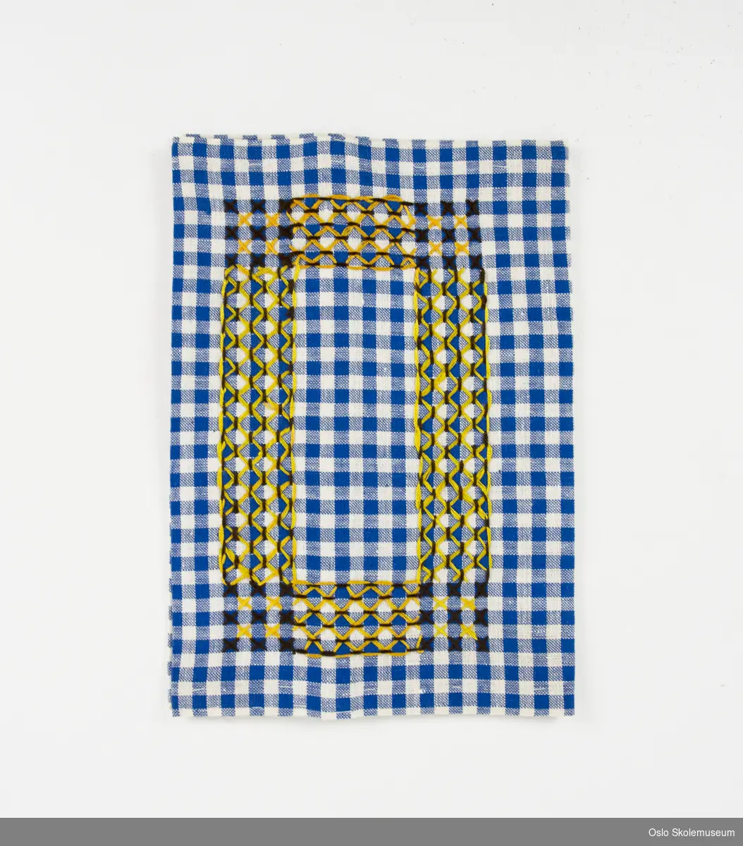 Bokbind sydd i hvit- og blårutete tekstil. På fremsiden er det brodert et mønster med gul og brun tråd.