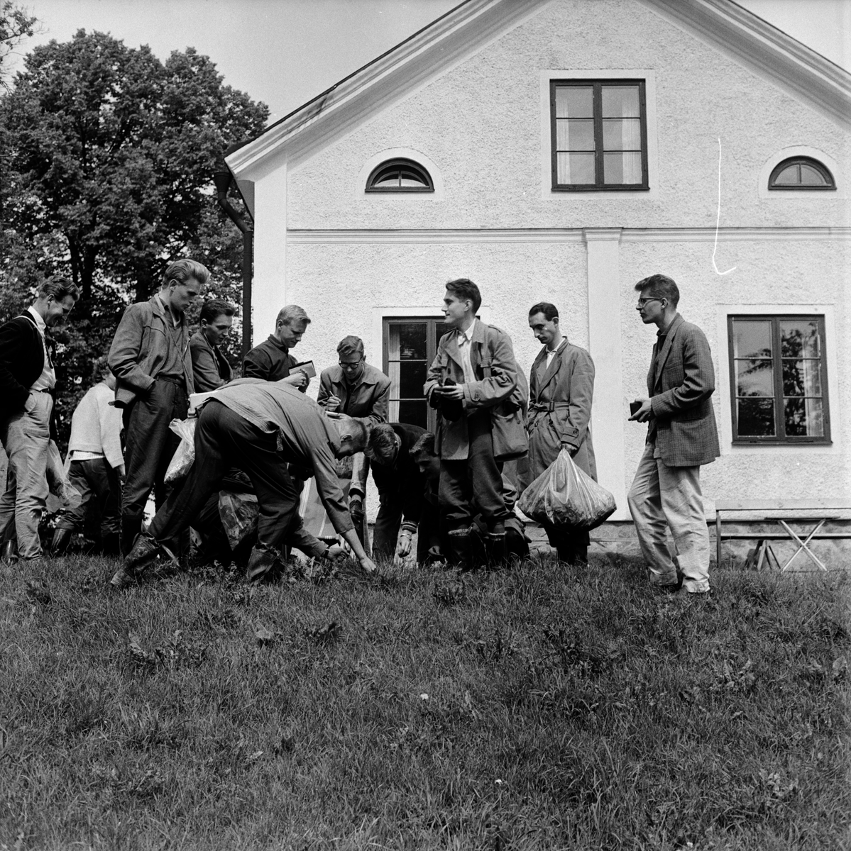Docent Lennart Holm har samlat sina kursdeltagare på en backslänt vid Vårdsätra och demonstrerar här Carvexart för dem, Vårdsätra, Uppsala, 1960