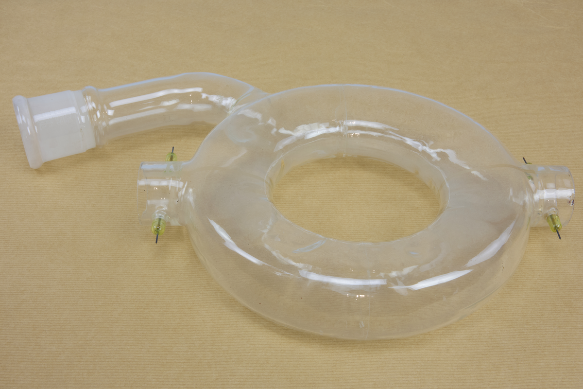 Toroidformad behållare av glas, med elektroder. Avsedd för betatron, en tidig typ av elektronaccelerator.