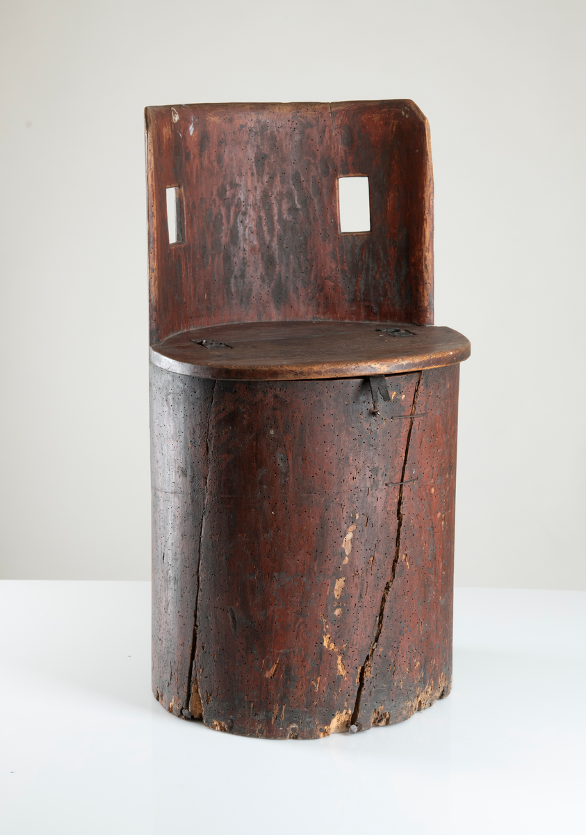 En urholkad trästock, ovanpå en uppfällbar sits som är försedd med gångjärn. Ryggstödet är halvcirkelformat med avrundade hörn, och med två rektangulära gluggar. Kan även kallas stabbstol eller kubbstol.