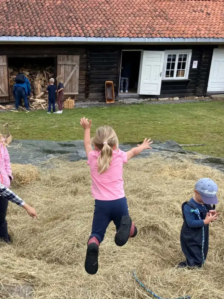 Barn som hopper i høyet.