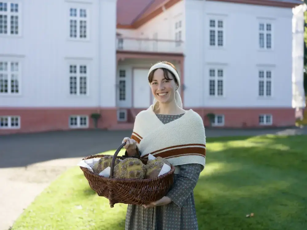 Jente med brødkurv foran Eidsvollsbygningen