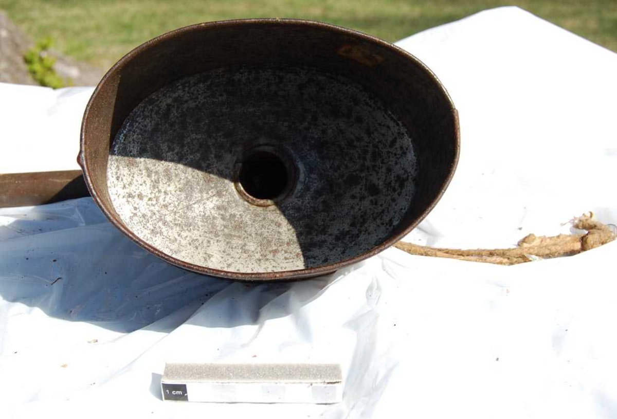 Form: Oval sylinder, vinkelrett rør ut av bunn.
