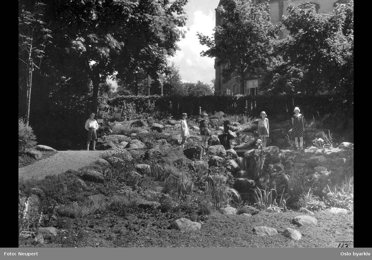 Barn ved steinbed med rennende vann, rock-garden. Vestkanttorget