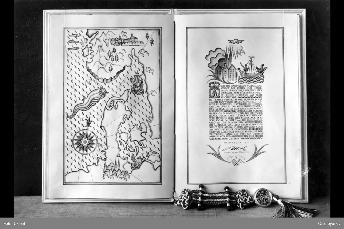 Oppslåtte sider i kunstferdig utsmykket og illustrert bokverk med segl og dusk. Utgitt i forbindelse med hansabyen Lübecks 700-årsjubileum som fri by. Hilsningsverk (datert juni 1926) fra Oslo by.
