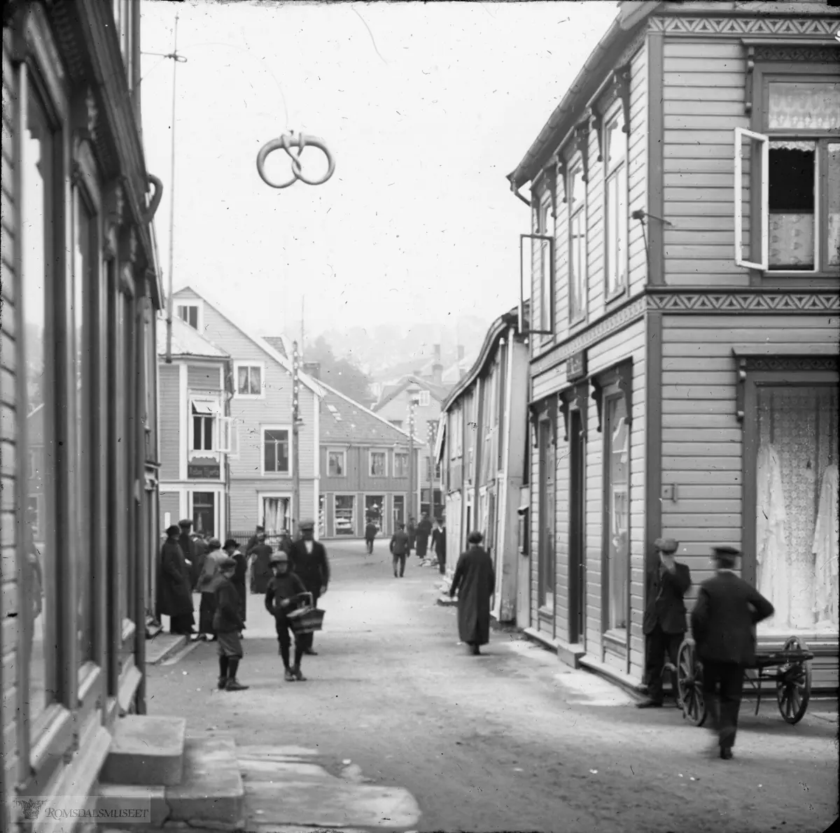 Storgata sett vestover.Kringlen som vises på bildet hører til baker Linds hus..med bla Anton Hjertøs butikk lenger oppe i gata på venstre side.